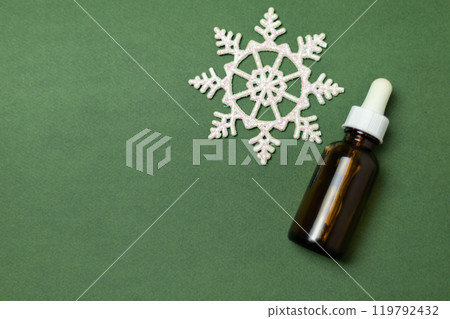 serum bottle with white snowflake on green background 119792432