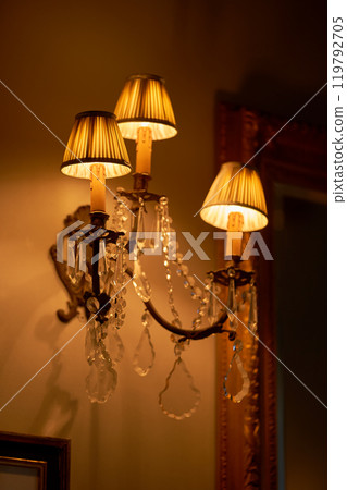 Splendid chandelier with lit candles in a beautiful room of an old mansion 119792705
