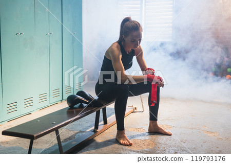 Women self defense girl power. Woman fighter preparing for fight wrapping hands with red boxing wraps sports protective bandages. Strong girl ready for fight active exercise sparring workout training 119793176