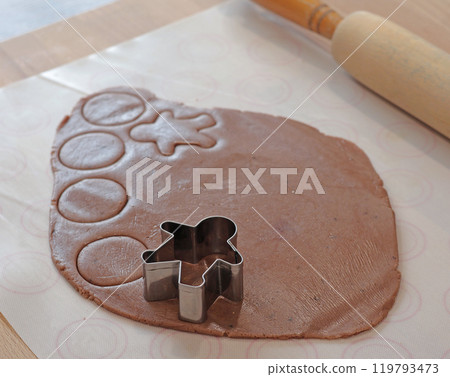 Rolled out gingerbread dough for Christmas gingerbread men. Holiday and cooking at home in the kitchen. Rolled out gingerbread dough for Christmas gingerbread men. Holiday and cooking at home in the kitchen. 119793473