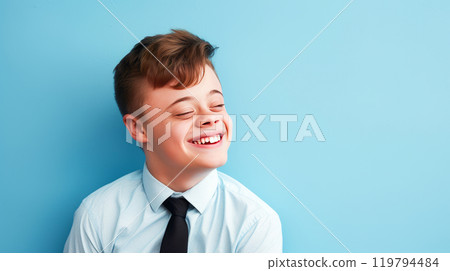 Portrait of smiling laughing teenager guy with Down syndrome blue background. 119794484