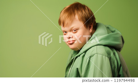Portrait of smiling laughing teenager guy with Down syndrome green background. 119794498