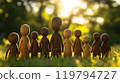 Intricately designed wooden figurines in a sunlit meadow embodying community spirit 119794727