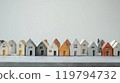 Miniature concrete houses aligned on smooth gray tabletop for urban planning presentations 119794732