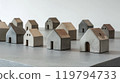 Miniature concrete houses arranged on a gray tabletop for urban planning presentations 119794733