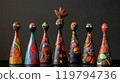 Colorful hand-painted ceramic figurines displayed on a black table against a plain background 119794736