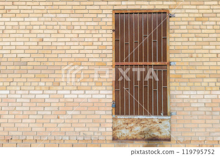 Brick Wall with Rusty Metal Door and Padlock 119795752