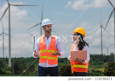 Team engineer wearing safety uniform holding laptop discussed plan about renewable energy at station energy power wind. technology protect environment reduce global warming problems. Team engineer wearing safety uniform holding laptop discussed plan about renewable energy at station energy power wind. technology protect environment reduce global warming problems. 119796071