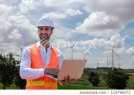 Engineer wearing safety uniform holding laptop discussed plan about renewable energy at station energy power wind. technology protect environment reduce global warming problems. 119796072