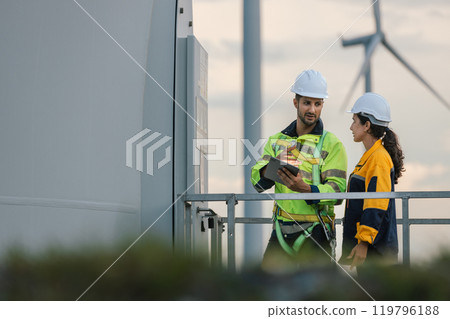 Team engineer wind turbine worker safety uniform survey discuss operational planning windmill field clean energy. Alternative technology protect environment reduce global warming problems. 119796188