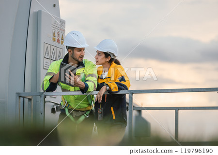 Team engineer wind turbine worker safety uniform survey discuss operational planning windmill field clean energy. Alternative technology protect environment reduce global warming problems. Team engineer wind turbine worker safety uniform survey discuss operational planning windmill field clean energy. Alternative technology protect environment reduce global warming problems. 119796190