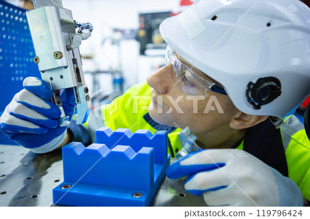 Male technician engineer checking automation robotic arm at industrial modern factory. man working at factory innovation automation robot. 119796424