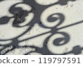 Blurry shadows of forged fence on grunge wall. Shadow patterns at rusty surface texture. 119797591