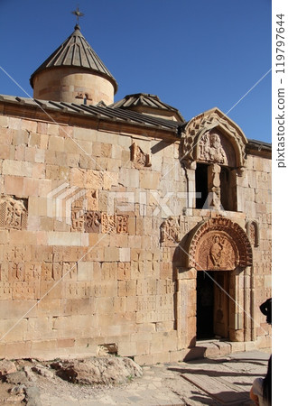Facade of a historic stone church with intricate carvings and inscriptions on the wall. Facade of a historic stone church with intricate carvings and inscriptions on the wall. 119797644