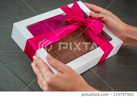 Trend Dubai chocolate with pistachio paste and kataifi dough in present box. Confectionery handmade sweets at home in the kitchen. Trend Dubai chocolate with pistachio paste and kataifi dough in present box. Confectionery handmade sweets at home in the kitchen. 119797802