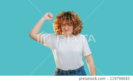 Female protest. Body shaming. Frustrated dissatisfied overweight chubby woman complaining striking with raised fist isolated on blue copy space background. 119798085