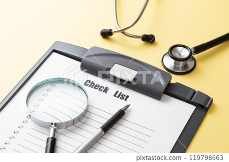 Stethoscope and checklist on a yellow background Stethoscope and checklist on a yellow background 119798663