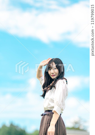 A woman standing under the blue sky 119799015
