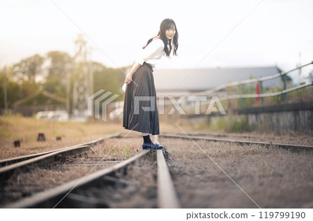 一名婦女在廢棄的鐵路線上行走 一名婦女在廢棄的鐵路線上行走 119799190