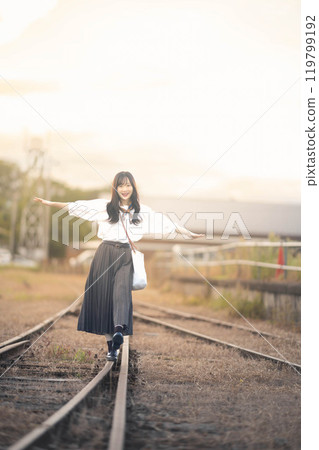 一名婦女在廢棄的鐵路線上行走 119799192