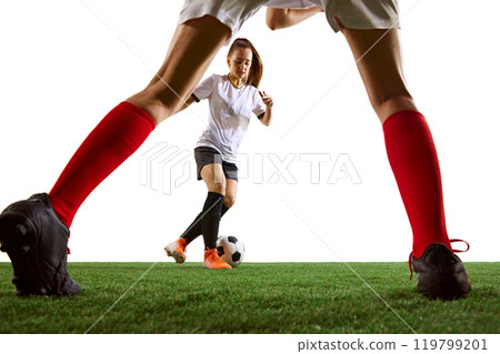 Perspective from unique angle, female soccer player preparing to hit the ball with focus and precision. Competitive moment. Perspective from unique angle, female soccer player preparing to hit the ball with focus and precision. Competitive moment. 119799201