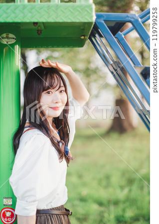 Woman playing on playground equipment in the park 119799258
