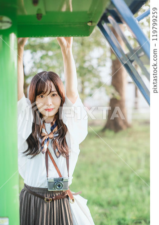 Woman playing on playground equipment in the park 119799259