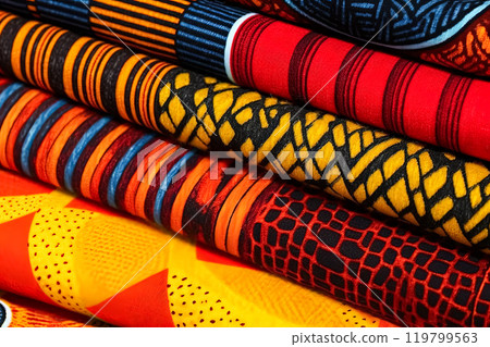 An array of fabric rolls adorned with intricate and colorful African designs An array of fabric rolls adorned with intricate and colorful African designs 119799563