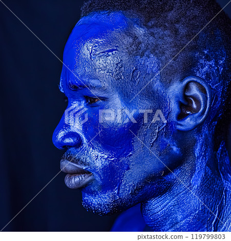 an African man adorned in vibrant blue paint 119799803