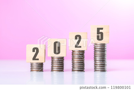 A stack of coins placed on top of a wooden block labeled '2025.' The image symbolizes financial growth and planning for the year ahead, highlighting the importance of saving and investment strategies 119800101