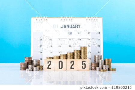 Stack of coins next to a wooden block labeled '2025' and a 2025 calendar. Financial planning and goal setting for the upcoming year, emphasizing the importance of budgeting and future investments 119800215