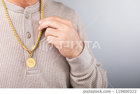 A close-up of a man wearing a gold necklace, symbolizing market speculation. Represents the concept of tracking gold prices, highlighting the connection between personal investment and market trends A close-up of a man wearing a gold necklace, symbolizing market speculation. Represents the concept of tracking gold prices, highlighting the connection between personal investment and market trends 119800322