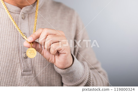 A close-up of a man wearing a gold necklace, symbolizing market speculation. Represents the concept of tracking gold prices, highlighting the connection between personal investment and market trends A close-up of a man wearing a gold necklace, symbolizing market speculation. Represents the concept of tracking gold prices, highlighting the connection between personal investment and market trends 119800324