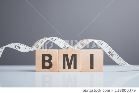 A wooden block displaying 'BMI' next to a measuring tape. The image symbolizes the concept of Body Mass Index, highlighting the importance of health metrics in tracking fitness and well-being A wooden block displaying 'BMI' next to a measuring tape. The image symbolizes the concept of Body Mass Index, highlighting the importance of health metrics in tracking fitness and well-being 119800379