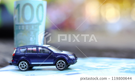 Model car with euro banknotes on blur background. Planning of saving for buying car, car loan and car insurance concept. Model car with euro banknotes on blur background. Planning of saving for buying car, car loan and car insurance concept. 119800644