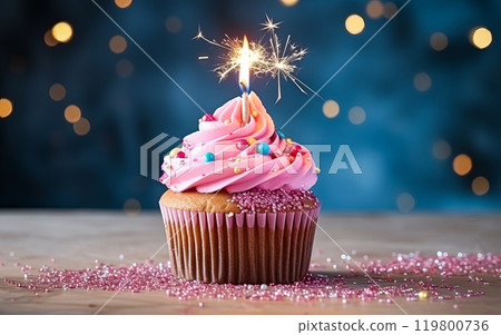 a birthday cake or muffin adorned with lights against a vibrant pink background. a birthday cake or muffin adorned with lights against a vibrant pink background. 119800736