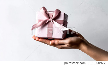 a girl holds a cute gift box in her hands on a light background 119800977