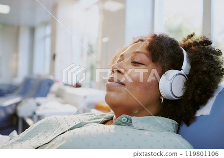 African American woman relaxing and listening to music with headphones in bright and cozy living environment evoking a sense of tranquility and comfort African American woman relaxing and listening to music with headphones in bright and cozy living environment evoking a sense of tranquility and comfort 119801106