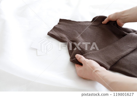A woman holding a simple brown knit A woman holding a simple brown knit 119801627
