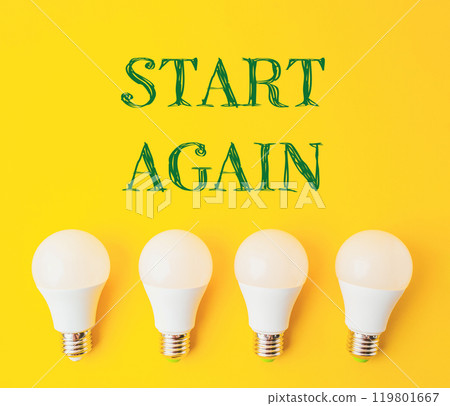 Four white light bulbs arranged in a row on a yellow background Four white light bulbs arranged in a row on a yellow background 119801667