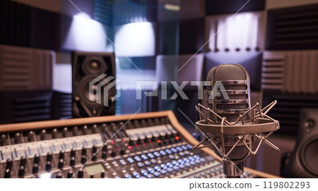 Vintage mic in front of soundproof booth, digital console ready to capture pristine audio. 119802293