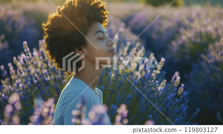 A person in a lavender field, eyes closed, breathes deeply, feeling serene and connected to nature. A person in a lavender field, eyes closed, breathes deeply, feeling serene and connected to nature. 119803127