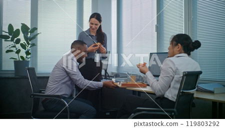 Multiethnic team of technical customer support specialists talk and eat pizza Multiethnic team of technical customer support specialists talk and eat pizza 119803292