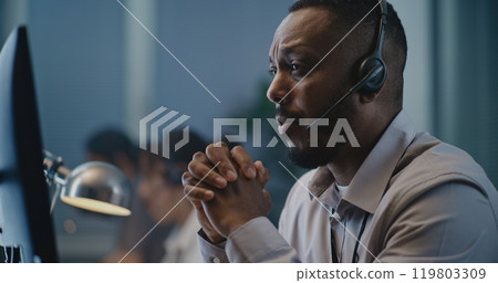 Portrait of African American hotline specialist in headset consulting person on call 119803309