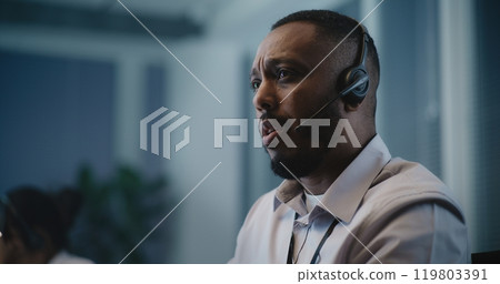 African American crisis helpline counselor in headset providing mental health support 119803391