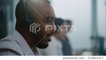 Close up of African American technical support specialist in headset helping online on phone call 119803417