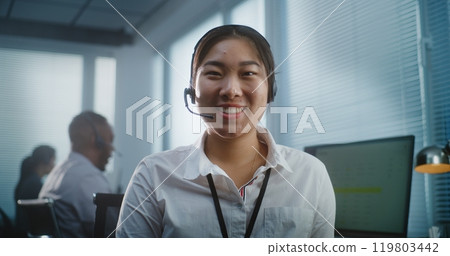 Close up portrait of friendly Asian female technical customer looking at camera Close up portrait of friendly Asian female technical customer looking at camera 119803442