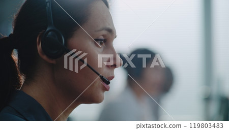 Close up of Caucasian female hotline operator in headset having conversation on call 119803483