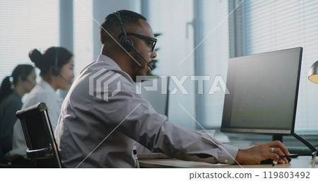 African American technical customer support specialist talking, working on computer 119803492