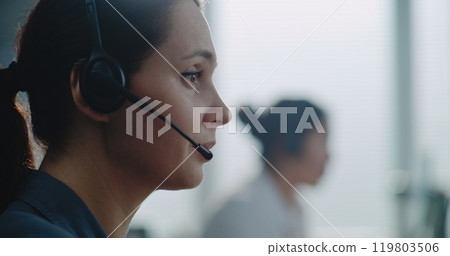 Close up of Caucasian female hotline operator in headset having conversation on call Close up of Caucasian female hotline operator in headset having conversation on call 119803506